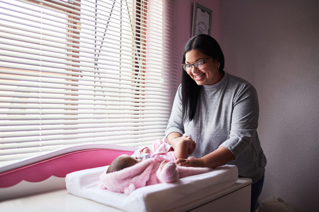 a confinement nanny in Singapore changing the baby's diaper on a table