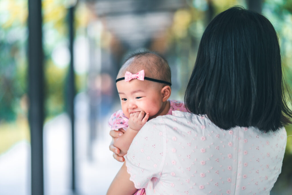 Trusted nanny carrying a baby in a safe and caring home environment.